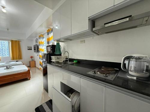 eine Küche mit Spüle und Herd Oberer Backofen in der Unterkunft Sea Residences Wonders in Manila