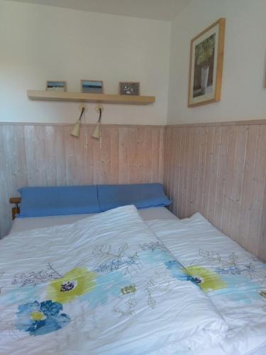a bed with a blue head board with flowers on it at Windspiel in Schönberg