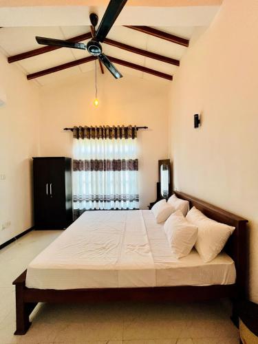 a bedroom with a large bed with a ceiling fan at Green Hill Villa Thalpe in Talpe
