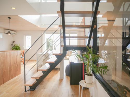 a staircase in a house with a potted plant at 新築サーファーズハウス棟貸しFLAG Awaji in Awaji