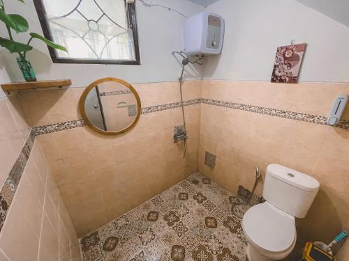 a bathroom with a toilet and a mirror at Avana Guesthouse in Kalasan