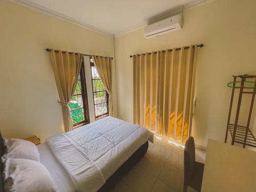 a bedroom with a bed and a window at Avana Guesthouse in Kalasan