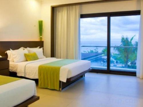 a bedroom with two beds and a view of the ocean at Ciriaco Hotel in Rauis