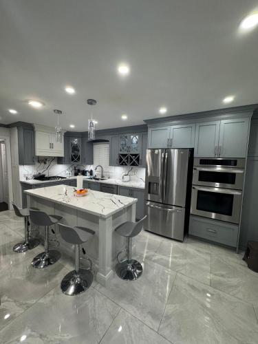 a large kitchen with a island in the middle of it at Pearson Gateway Comfort Home in Mississauga