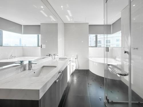 een witte badkamer met twee wastafels en een douche bij D'Rapport Residences by Manhattan Group in Kuala Lumpur