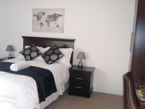 a bedroom with a bed and a nightstand with a bed sidx sidx sidx sidx at La Coscello Guest House in Edenvale