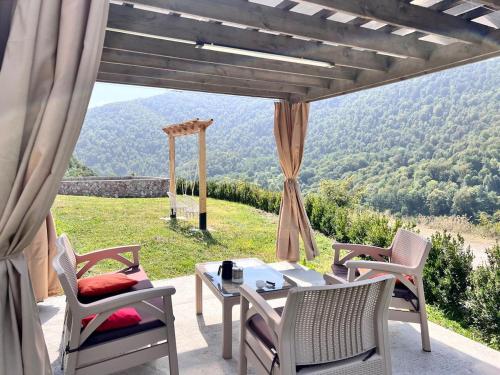een patio met een tafel en stoelen en uitzicht bij Green Villa Resort White in Dilidzjan
