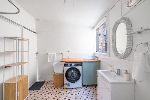 a white bathroom with a washing machine in it at The Fishin' Shack in Burrill Lake