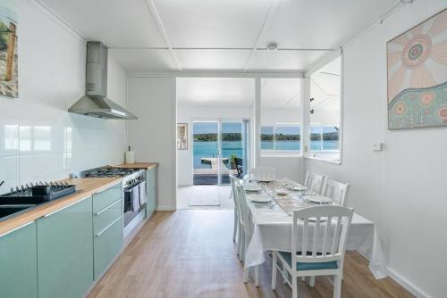 a kitchen and dining room with a table and chairs at The Fishin' Shack in Burrill Lake