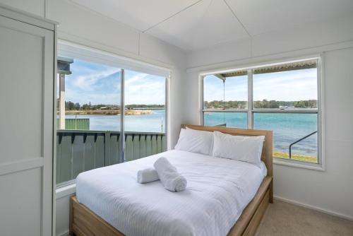 a bedroom with a bed with a view of the water at The Fishin' Shack in Burrill Lake