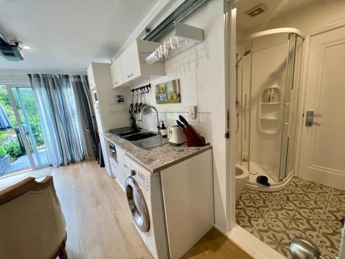a kitchen with a washer and a washing machine at Dove Cottage in Auckland