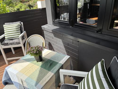 een tafel en stoelen op een veranda met een tafel en bloemen bij Courtyard Pool Studio Private Luxe Retreat in Coal Point