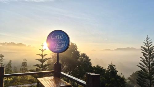 a sign on top of a mountain with fog in the valley at One khaokho homestay in Khao Kho
