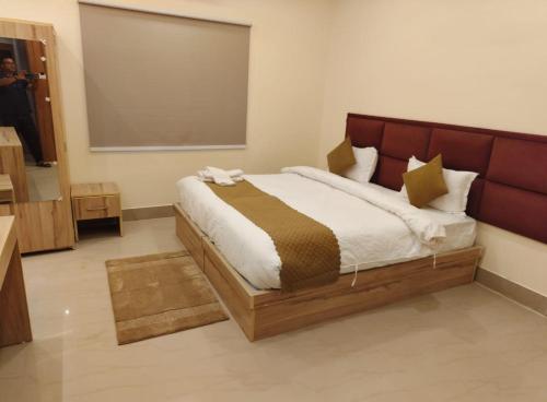 a bedroom with a large bed with a brown headboard at Hotel SJ corporate in Bhubaneshwar