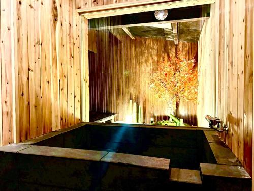 a swimming pool in a wooden room with a tree at 伊勢別邸風音 in Ise