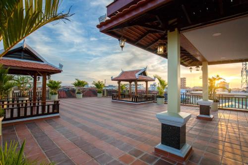 un gran patio con 2 cenadores en un edificio en Seng Hout Hotel, en Battambang