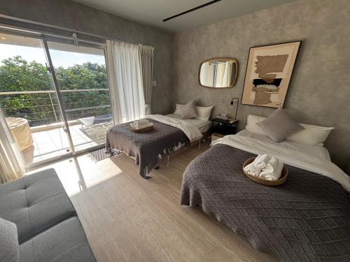 En eller flere senge i et værelse på Plus Life Shiraho A号室