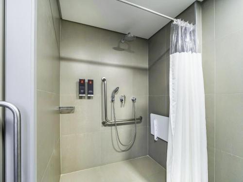 a shower with a shower curtain in a bathroom at Mercure Sao Paulo Barra Funda in Sao Paulo