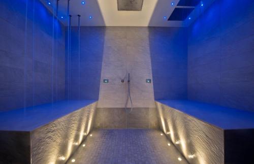a bathroom with a shower with blue lighting at Hotel Mioni Pezzato in Abano Terme