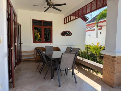 a dining room with a table and chairs on a patio at Private Pool-Villa Baan Roth, Gated community 24/7 in Hua Hin
