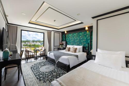 a hotel room with two beds and a balcony at Cherry Đà Lạt 3 - Luxury Hotel in Da Lat