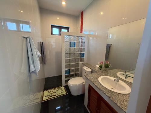 a bathroom with a sink and a toilet and a mirror at Private Pool-Villa Baan Roth, Gated community 24/7 in Hua Hin