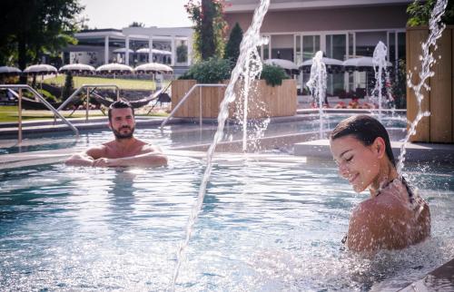 a man and a girl playing in a fountain at Hotel Mioni Pezzato in Abano Terme