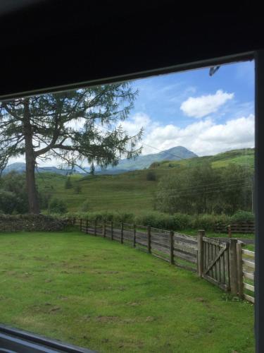 a view from a window of a field with a fence at Garrison Farm with Hot Tub in Inversnaid