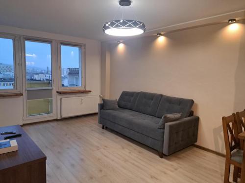 ein Wohnzimmer mit einer Couch und einigen Fenstern in der Unterkunft Apartament Gdynia in Gdynia