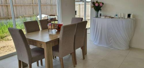 een eettafel en stoelen in een kamer met een tafel bij Quiet Spacious Room in Yarrabilba 
