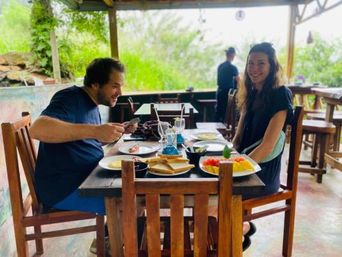 Ein Mann und eine Frau sitzen an einem Tisch in der Unterkunft Green Vista Ella in Ella