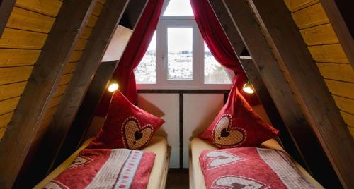 two beds in a small room with a window at Haus Sternenblick 22 in Freyung