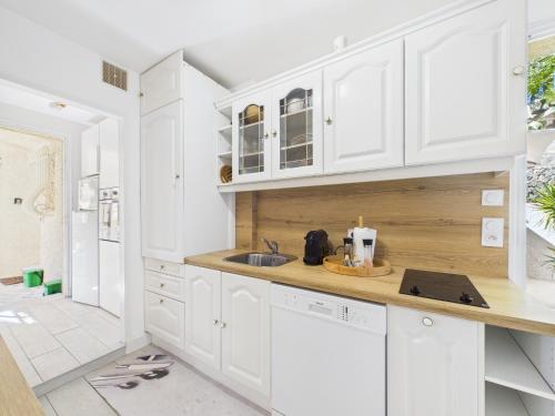 une cuisine avec des armoires blanches et un évier dans l'établissement Les Lodges de Saint Cassien 2, à Montauroux