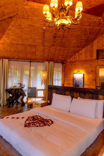 a bedroom with a large white bed with a chandelier at Kilimani Villa in Moshi