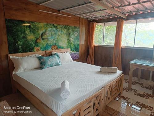a bedroom with a large bed with a painting on the wall at Ashokavanam Heritage Village by N Square in Kanthalloor