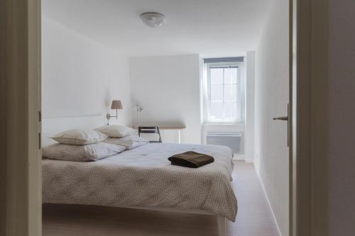Habitación blanca con cama y ventana en Les Hauts de Colmar, en Colmar