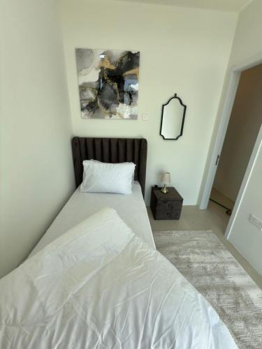 a bedroom with a white bed and a mirror at Nuchiii residence in Dubai