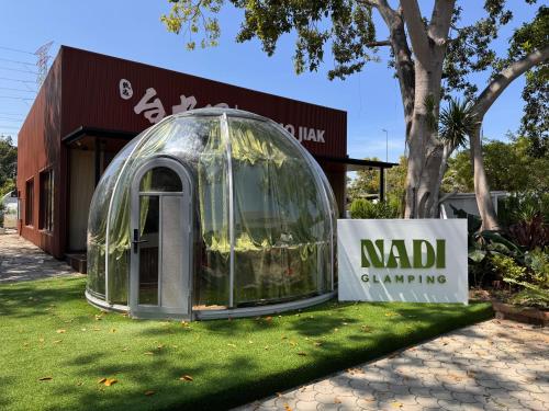 una casa a cupola sull'erba di fronte a un edificio di Nadi Glamping Suites a Perai