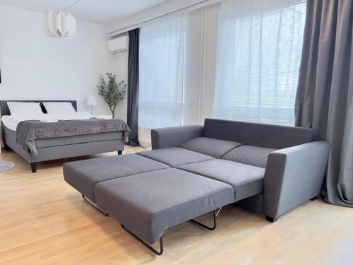 een woonkamer met een bank en een bed bij Modern Airport Apartment in Vantaa