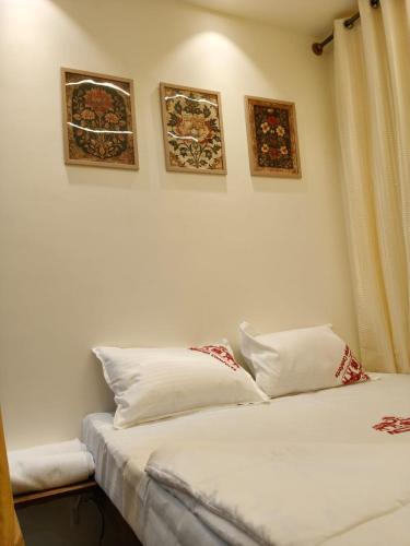 two beds in a room with pictures on the wall at Nisarga Comforts in Chikmagalūr