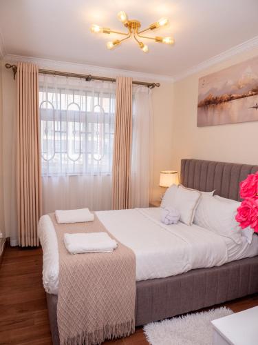a bedroom with a bed and a ceiling fan at Hazel's Condo-Luxury 3 Bedroom in Nakuru