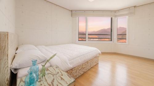 una camera da letto con un letto e due finestre di Gapyeong Applerotgi Pension a Gapyeong