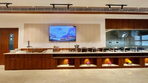 een grote keuken met een tv aan de muur bij Le OVAL Hotel & Resorts in Nakraunda