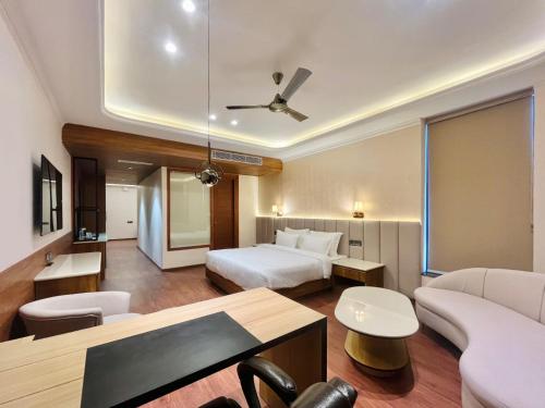 een hotelkamer met een bed en een bank bij Le OVAL Hotel & Resorts in Nakraunda