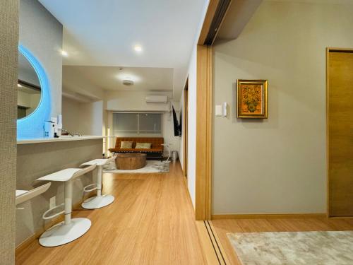 a hallway with two white stools in a room at LuxurySweet East71 最大7人 ペット可 箱崎宮前駅徒歩3分 新築 in Fukuoka