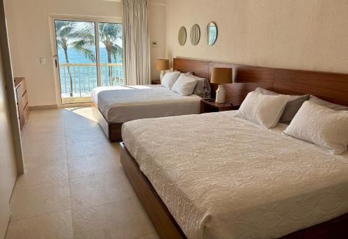een hotelkamer met twee bedden en een raam bij Condo at Krystal Grand Resort in Bucerías