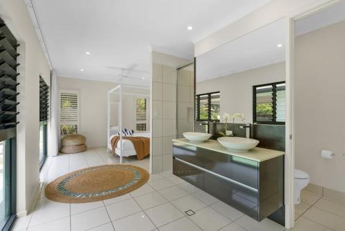 a bathroom with two sinks and a large mirror at Belle Escapes Sandcastles in Palm Cove