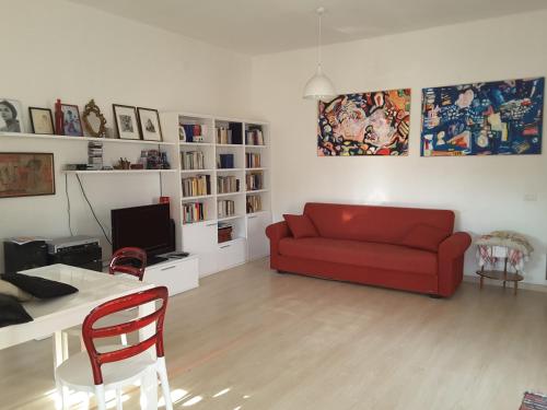 a living room with a red couch and a table at Casa Isabella in Calasetta