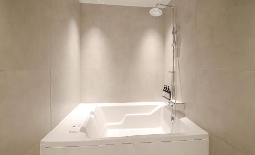 a white bathroom with a sink and a shower at 호텔인카페 파주금촌점 in P'aju