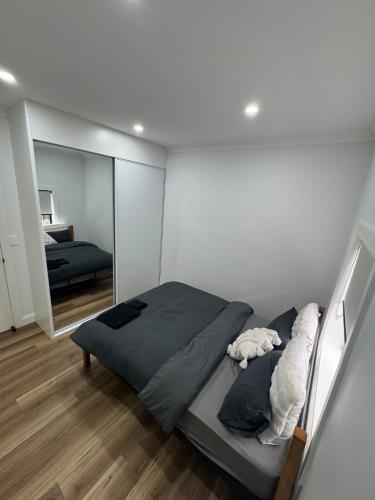 a bedroom with a bed and a large mirror at HOME away from HOME in Sydney
